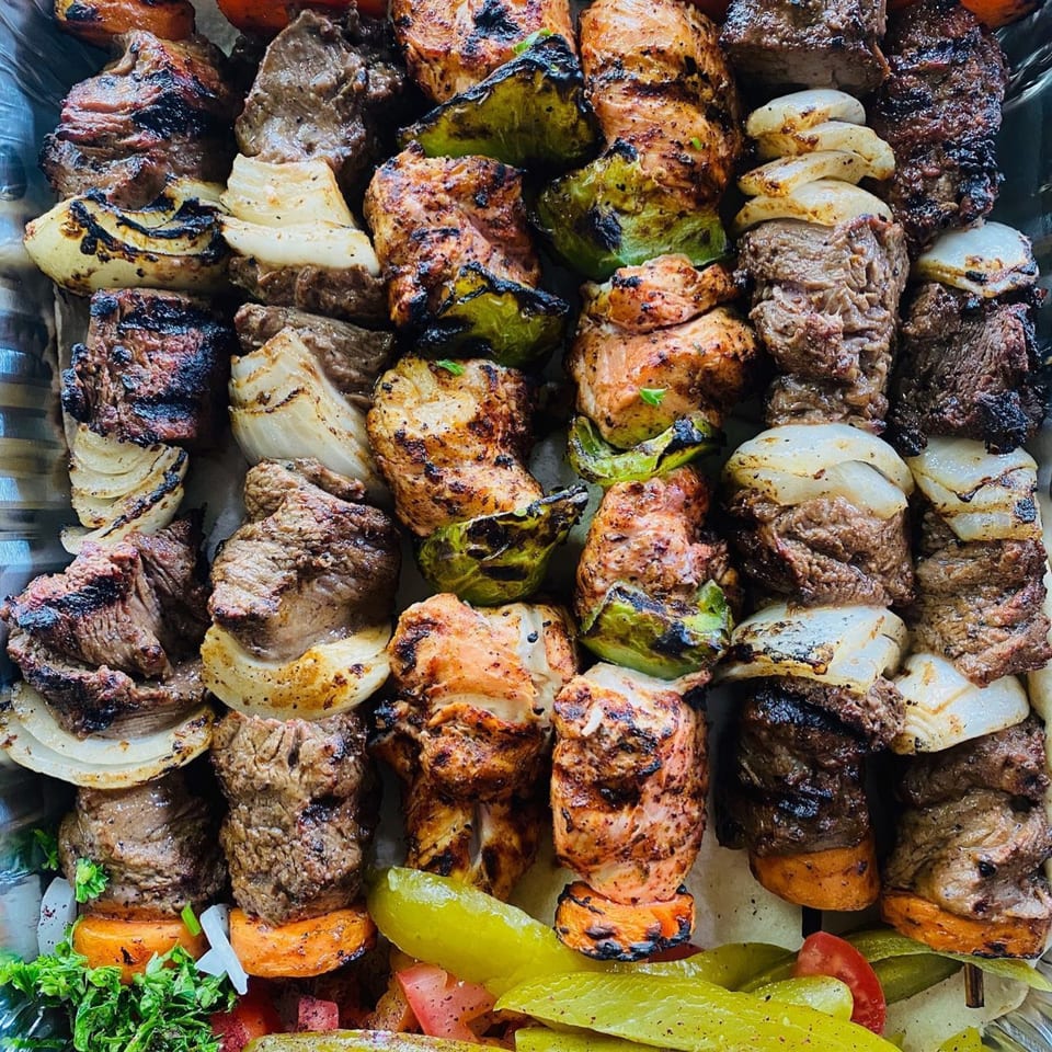 Close-up of grilled Shish Kabob Xpress skewers with beef, chicken, onions, and green peppers.